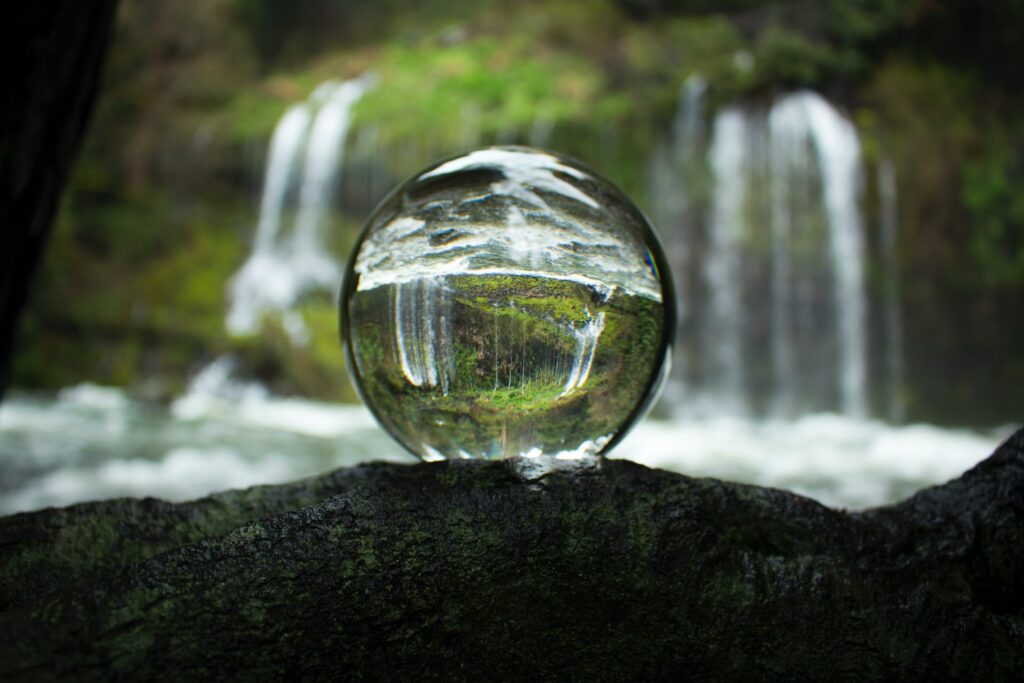 glass orb with waterfall behind